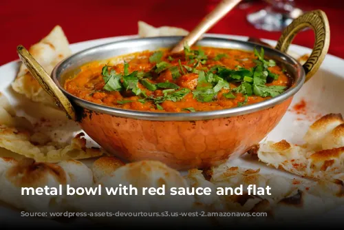 metal bowl with red sauce and flat bread