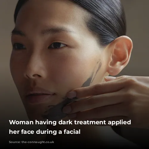 Woman having dark treatment applied to her face during a facial