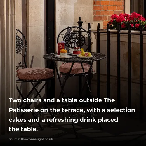 Two chairs and a table outside The Connaught Patisserie on the terrace, with a selection of cakes and a refreshing drink placed on the table.