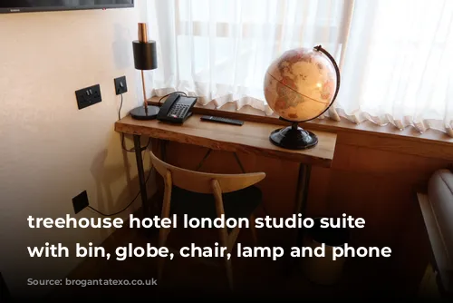 treehouse hotel london studio suite desk with bin, globe, chair, lamp and phone