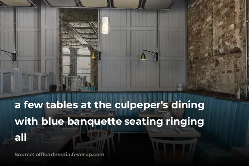 a few tables at the culpeper's dining room, with blue banquette seating ringing them all