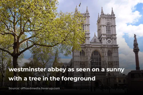 westminster abbey as seen on a sunny day with a tree in the foreground