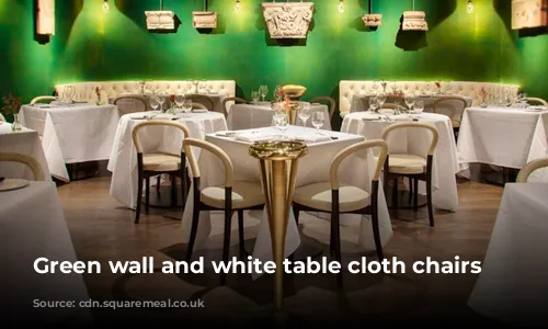 Green wall and white table cloth chairs