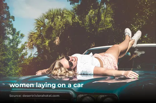 women laying on a car