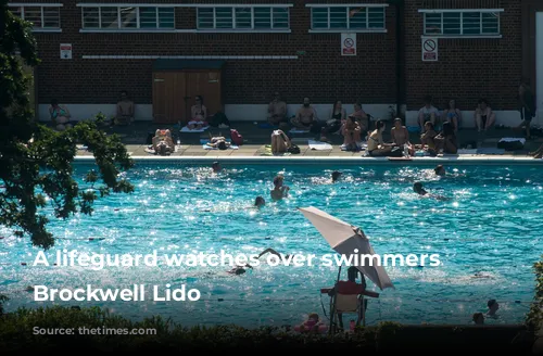 A lifeguard watches over swimmers at Brockwell Lido