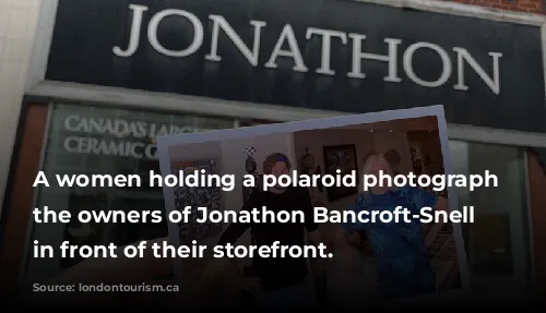 A women holding a polaroid photograph of the owners of Jonathon Bancroft-Snell Gallery in front of their storefront.