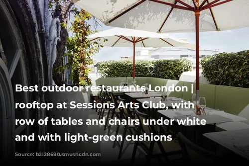 Best outdoor restaurants London | The rooftop at Sessions Arts Club, with a row of tables and chairs under white umbrellas and with light-green cushions