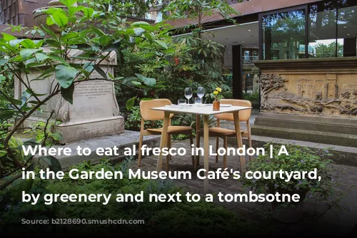 Where to eat al fresco in London | A table in the Garden Museum Café's courtyard, surrounded by greenery and next to a tombsotne