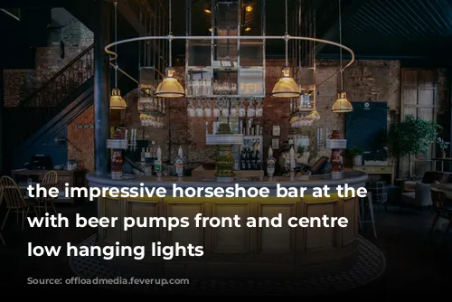 the impressive horseshoe bar at the culpeper, with beer pumps front and centre and low hanging lights