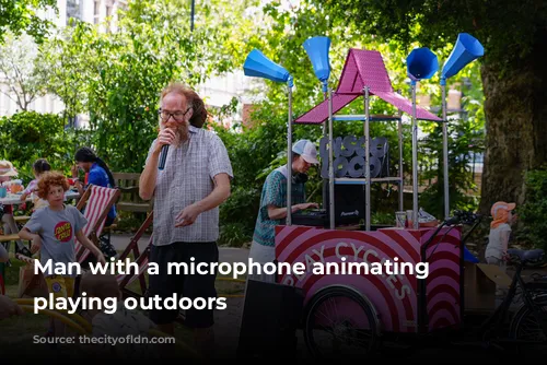 Man with a microphone animating children playing outdoors