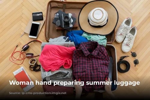 Woman hand preparing summer luggage