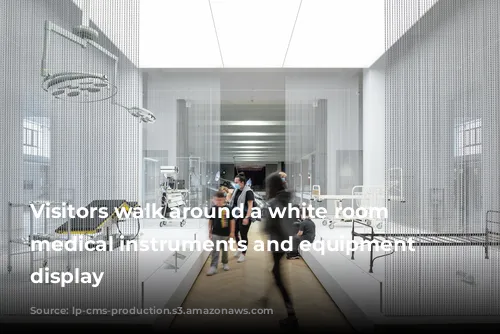 Visitors walk around a white room with medical instruments and equipment on display 