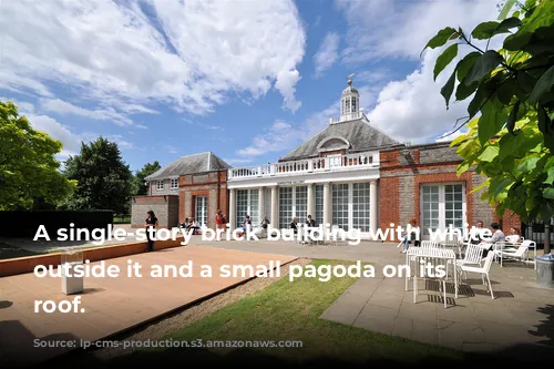 A single-story brick building with white columns outside it and a small pagoda on its pointed roof.