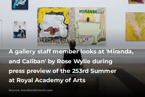 A gallery staff member looks at 'Miranda, Twice and Caliban' by Rose Wylie during a press preview of the 253rd Summer Exhibition at Royal Academy of Arts