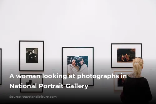 A woman looking at photographs in the National Portrait Gallery