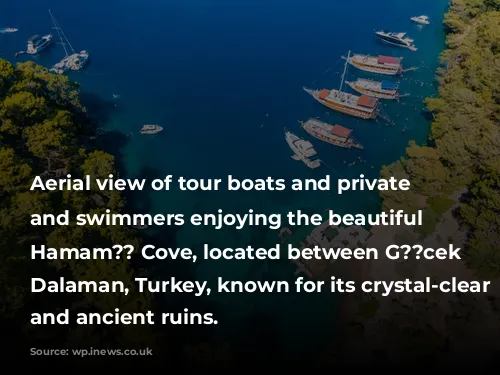 Aerial view of tour boats and private yachts and swimmers enjoying the beautiful Kleopatra Hamam?? Cove, located between G??cek and Dalaman, Turkey, known for its crystal-clear waters and ancient ruins.