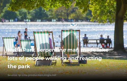 Hyde Park Serpentine man made lake and lots of people walking and reacting in the park