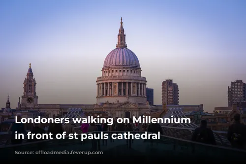 Londoners walking on Millennium bridge in front of st pauls cathedral